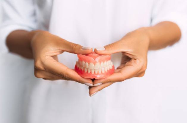 Lady presents viewer with dentures