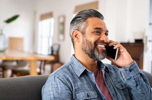 Man smiling while talking on phone
