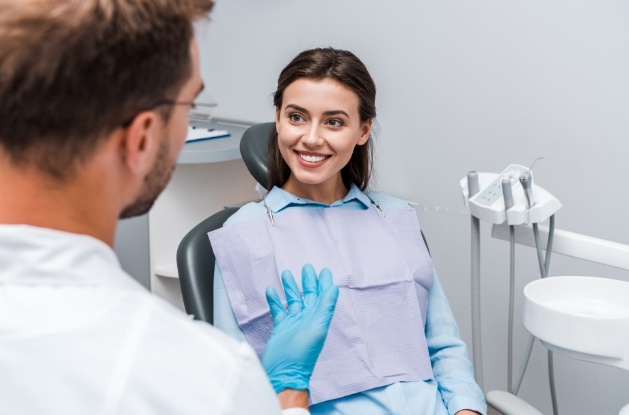 Brunette woman in dental chair listening to her dentist