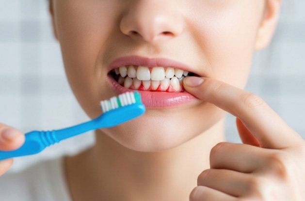 Person with a toothbrush and bleeding gums 