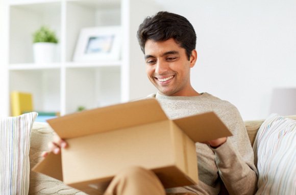 Smiling man holding package at home
