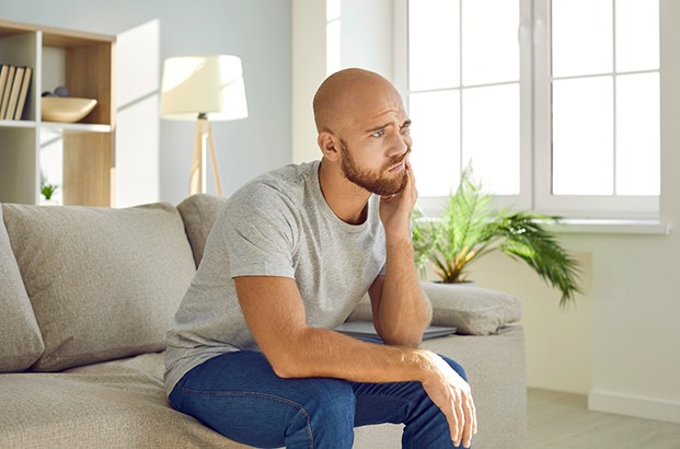 Man struggling with tooth pain at home
