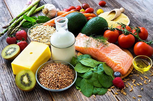 Various healthy foods piled together on a wooden table