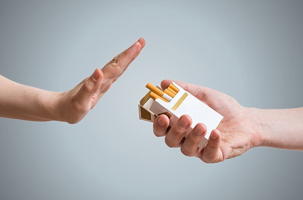 A hand turning down an offering of cigarettes