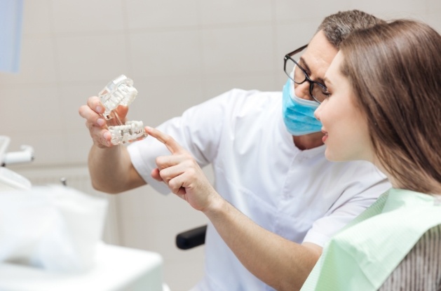 Dentist showing a dental implant to a patient