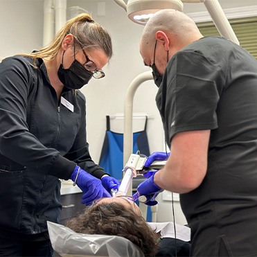 Dentist and dental team member treating a patient