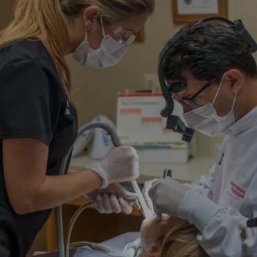 Dentist and assistant treating a dental patient