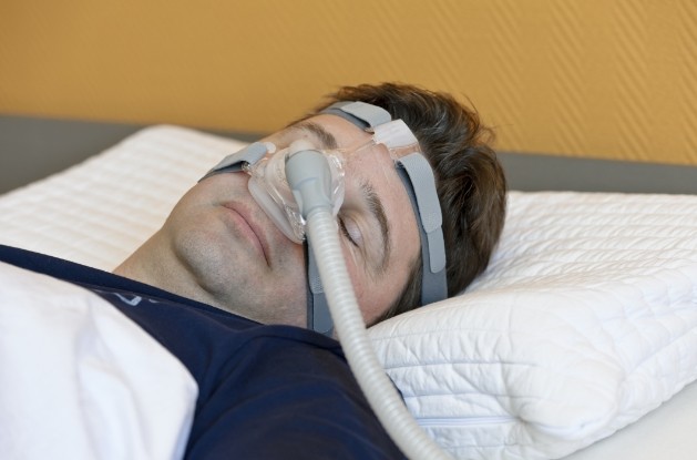 Sleeping man wearing C P A P mask for sleep apnea treatment