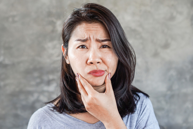 Patient holding cheek after a tooth extraction