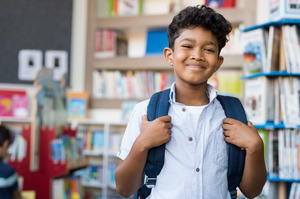 Smiling child with backpack at school